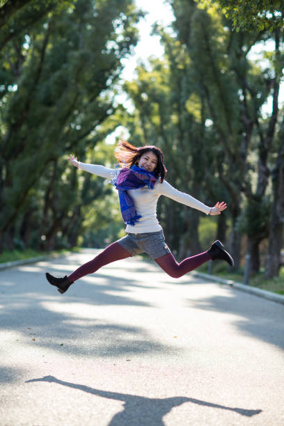 istock Japanese girl jumping outside 858534390