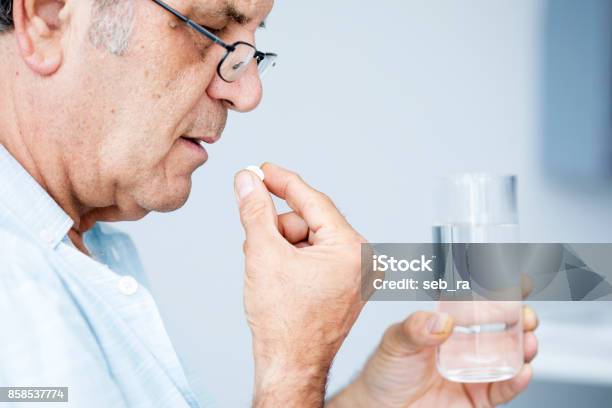 Old Man Taking A Pill Stock Photo - Download Image Now - Taking Pills, Senior Men, Men