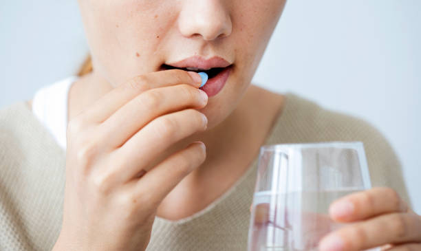 joven mujer tomando una píldora - capsule pill medicine antibiotic fotografías e imágenes de stock