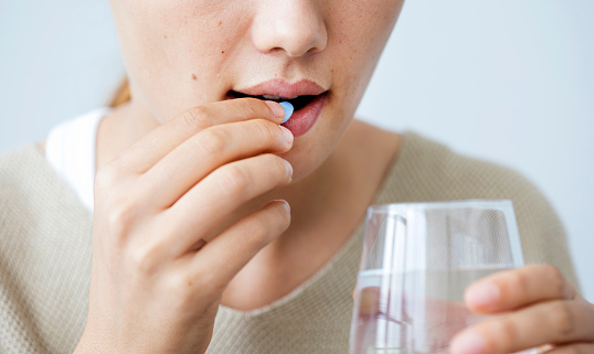 Young woman taking a pill