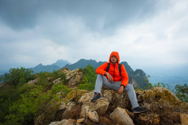 istock An Asian photographer rests on a stone, the peak behind the Great Wall 858538532