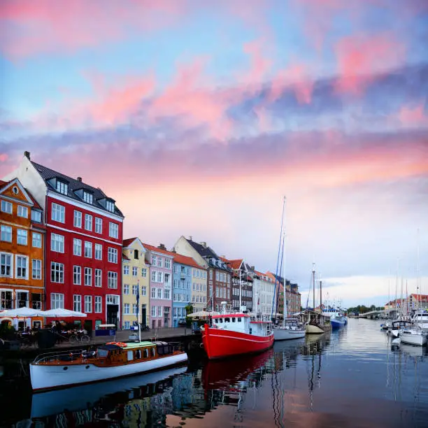 Nyhavn in Copenhagen is one of the most popular tourist places in dusk, Denmark. Composite photo