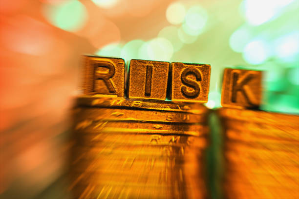 istock RISK copper alphabet on coin stack in radial blur illuminated with light 858546652