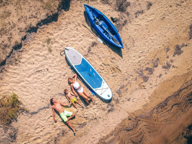 giovane famiglia che prende il sole - surfing beach family father foto e immagini stock