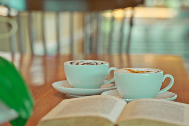 Vintage filter, couple of White coffee cup on wood table with blurred cafe bokeh light background.