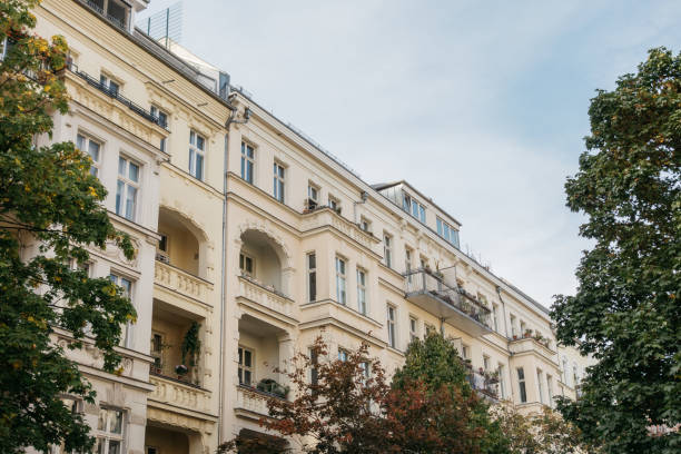 istock yellow apartment buildings framed by green trees 858557472