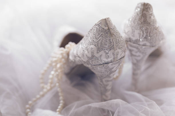 Elegant white high heels for bride at wedding on table of copper pennies