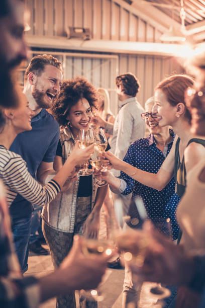 groupe de personnes gaies grillage avec du vin sur une partie. - champagne flute champagne black wineglass photos et images de collection