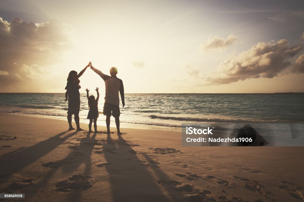 happy family with kids play at sunset beach silhouette of family with two kids on play on sunset beach Family Stock Photo