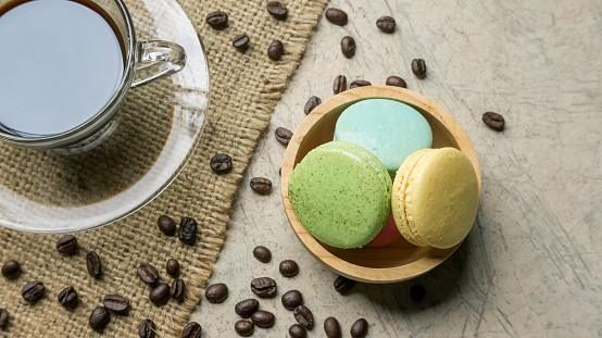 Colorful macaroons and a coffee on gray background.