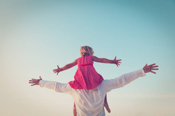 istock Father and little daughter play at sky 858570416