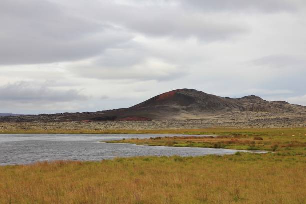 istock Old lava fields, green meadow and pond in Iceland. 858572420
