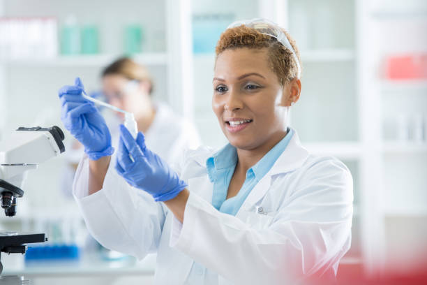 istock Mid adult lab technician holds a pipette and bottle eye level during experiment 858575778