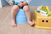 かわいい小さなアジア 18 ヶ月幼児赤ちゃん男の子子供のトイレ、木製のブロックのおもちゃで遊んでの上に座って足のクローズ アップ