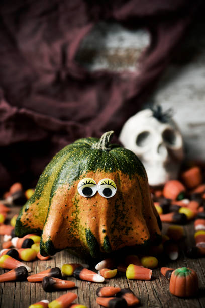 istock pumpkin with funny eyes, candies and skull 858590898