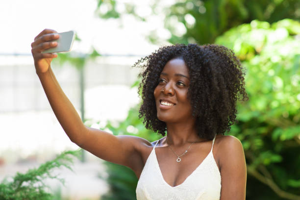 istock Smiling Black Lady Taking Selfie Photo in Park 858591572