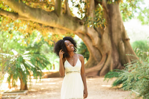 istock Smiling Dreamy Black Woman Walking in Park 858591704