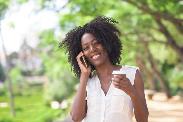 istock Cheerful young woman with coffee talking on phone 858591812