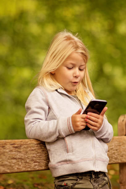 istock Beautiful young blond girl using smart phone in Autumnal Park 858596462