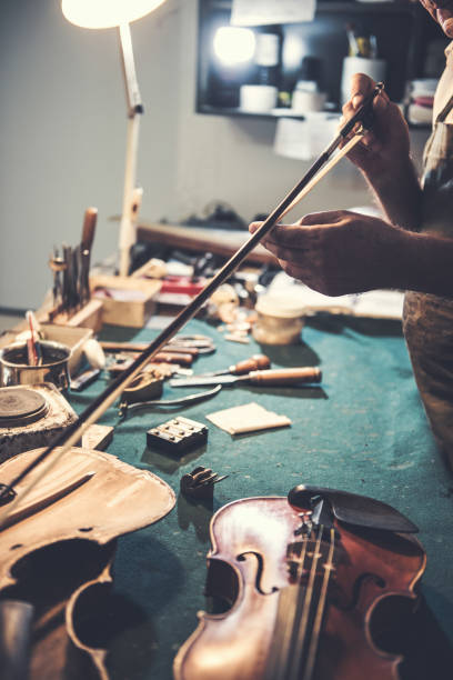 istock Repairman checking the fiddle bow on the violin 858599490