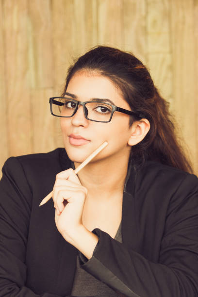 istock Flirty young female student reading book at table 858600502