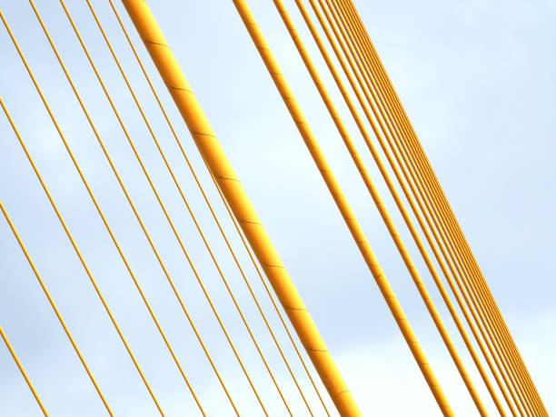 istock Diagonal two row stacked yellow cable line, grey cloudy sky 858604140