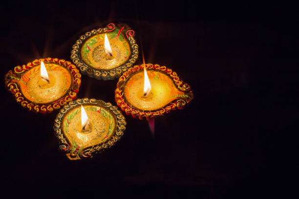 istock Four burning colorful clay diya lamp Diwali celebration. Black background. 858614868