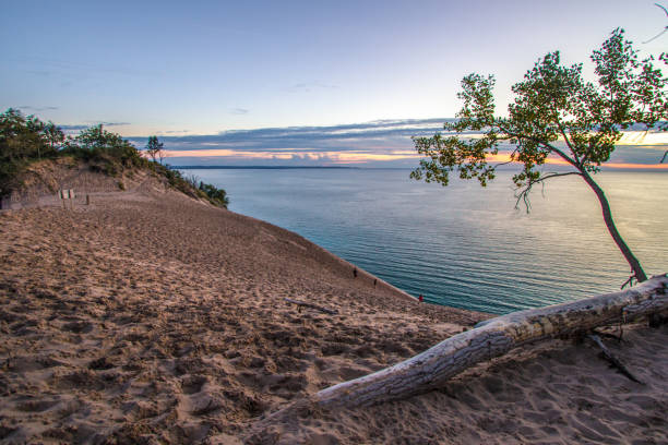 Blue water horizon over Lake Michigan with a massive sand dune in the foreground at Sleeping Bear Dunes National Lakeshore in Michigan.