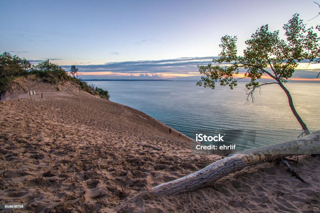 Sunset At Sleeping Bear Dunes National Lakeshore Blue water horizon over Lake Michigan with a massive sand dune in the foreground at Sleeping Bear Dunes National Lakeshore in Michigan. Sleeping Bear Dunes National Lakeshore Stock Photo