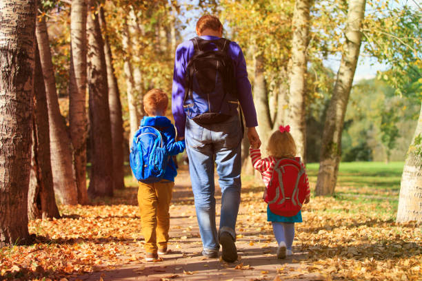 istock father with little son and daughter going to school 858622438