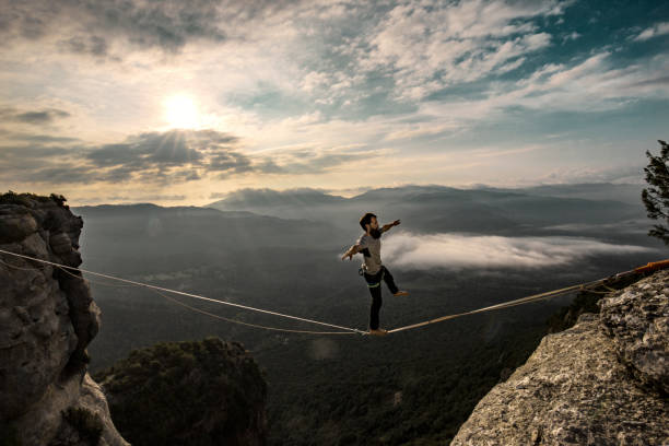 highlining in montagna all'alba - tightrope balance walking rope foto e immagini stock