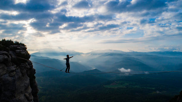 山でスラック ライン - tightrope balance walking rope ストックフォトと画像