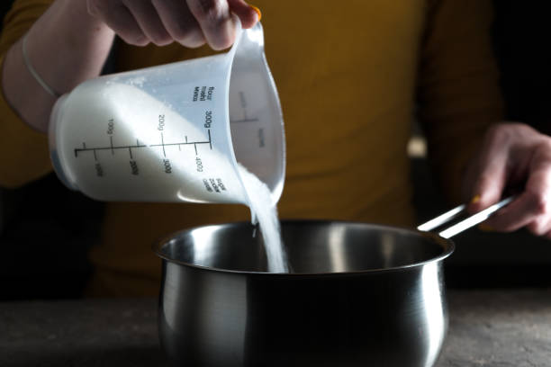 istock Sugar granulated sugar is poured into the saute pan side view 858623160