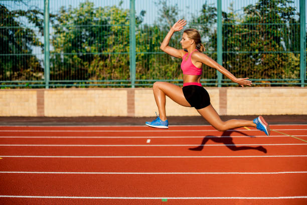 istock Side view beautiful young woman exercise jogging and running on athletic track on stadium 858626508