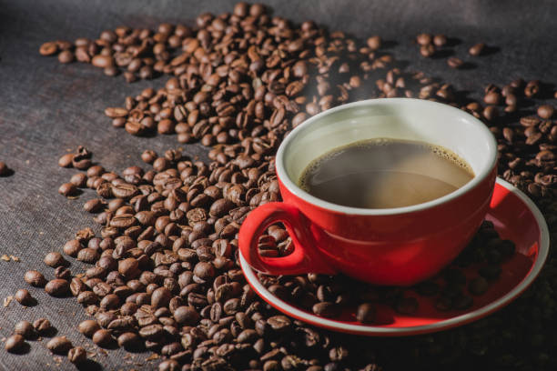 istock Hot coffee in red cup and coffee beans are the background. 858629852