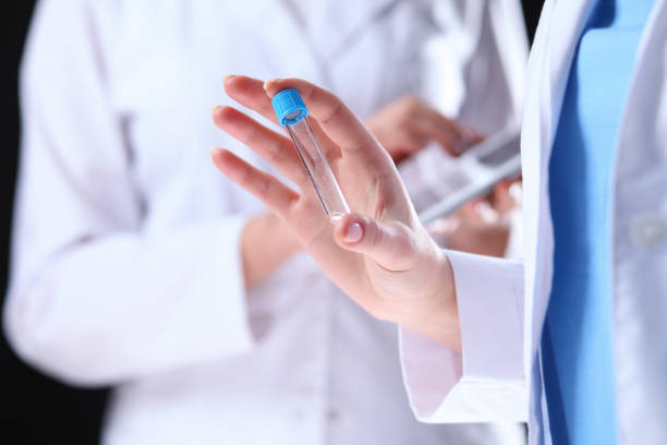 istock Close-up of scientific research team with clear solution in laboratory 858639424