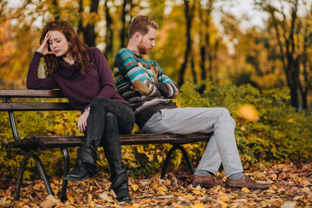 istock Angry redhead couple ignoring each other in the park. 858643040