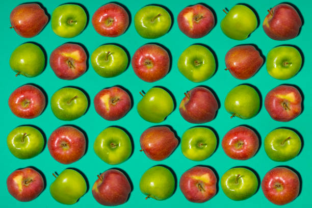 istock Red and green apples on Green colored background 858643364