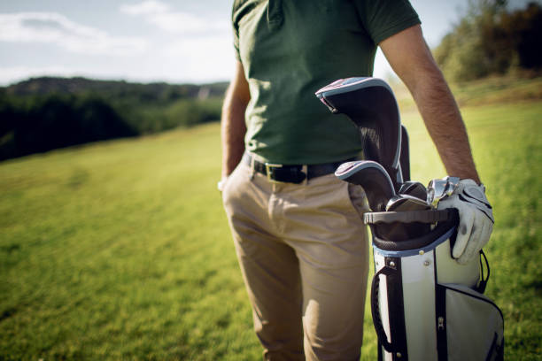 istock Golf player walking and carrying bag on course during summer game golfing 858646596