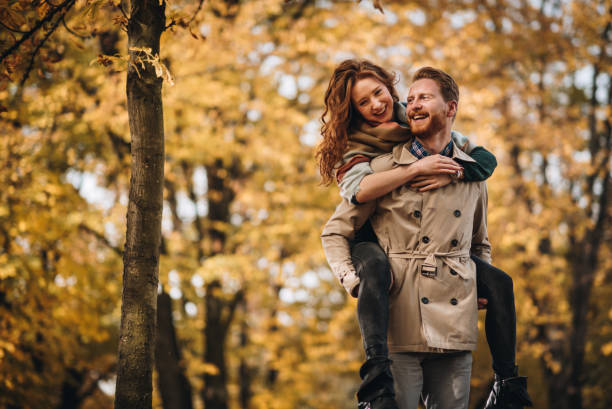 istock Happy ginger couple having fun while piggybacking in nature. 858654460