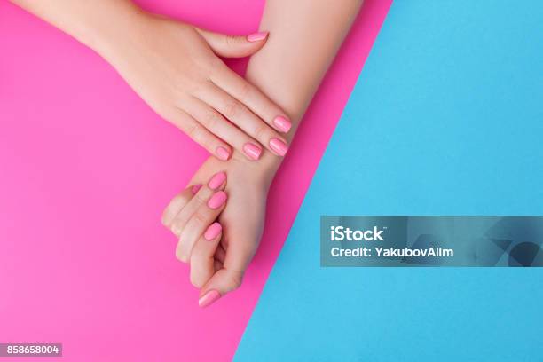 Closeup Of Hands Of A Young Woman With Manicure On Nails Against Pink Background Stock Photo - Download Image Now