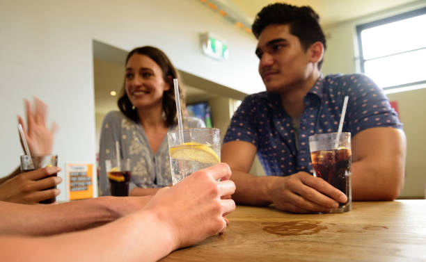 молодые взрослые в баре, веселясь, сосредотачиваются на выпивке - australia aborigine group of people friendship стоковые фото и изображения