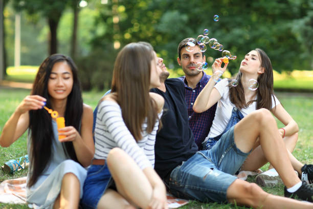 istock Best friends resting in park and blowing soap bubbles 858659158