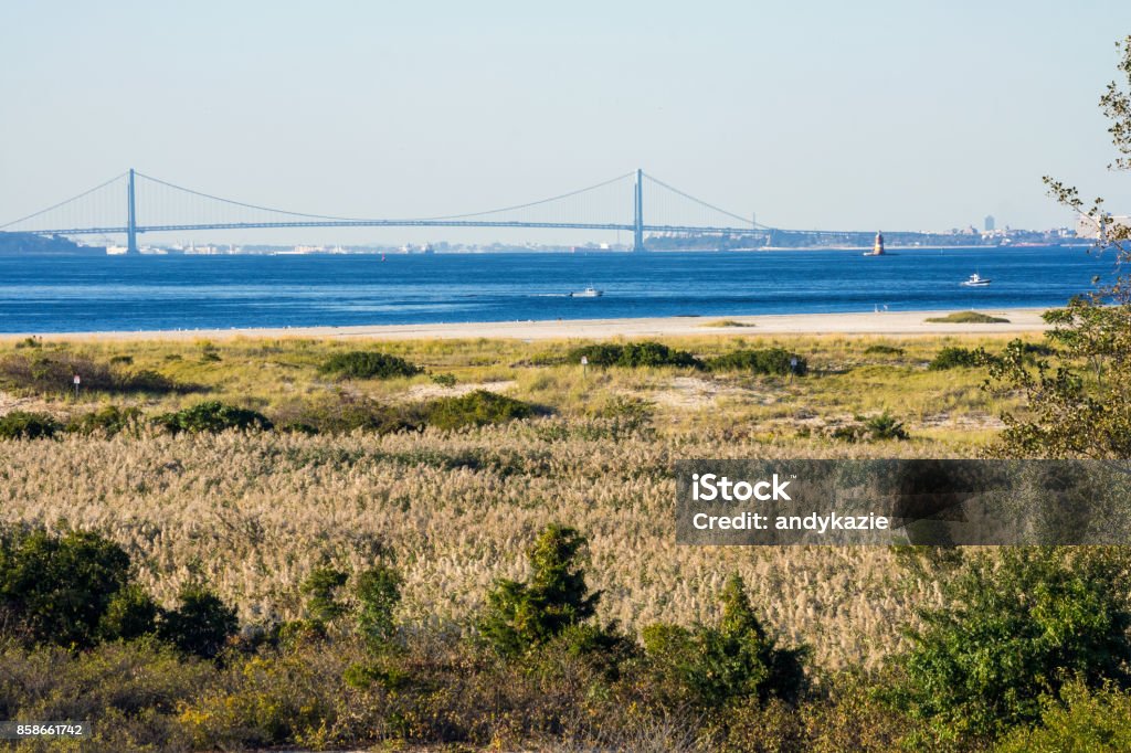 The Verrazano from Sandy Hook A scenic look at the Verrazano Narrows Bridge from across the Sandy Hook and Lower Bay. Bay of Water Stock Photo