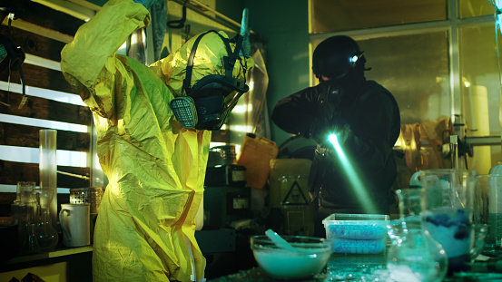 Fully Armed Special Anti-Narcotics Task Forces Soldier Arrests Clandestine Chemist in the Drug Producing Underground Laboratory. Chemist Raises Hands and Surrenders. A lot of Functional Drug Production Equipment is Standing Around. Shot in Slow Motion.