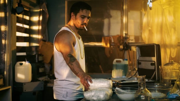 dans le laboratoire souterrain smoking hardcore garage place packs de brique avec des médicaments dans la valise pour davantage de vente et de distribution. il squatte dans le bâtiment abandonné avec windows montés à bord vers le haut. - meth lab photos et images de collection