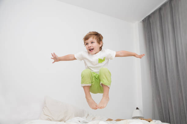 istock Cheerful little boy  jumping on bed at home 858663290