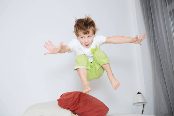 istock Cheerful little boy  jumping on bed at home 858663294