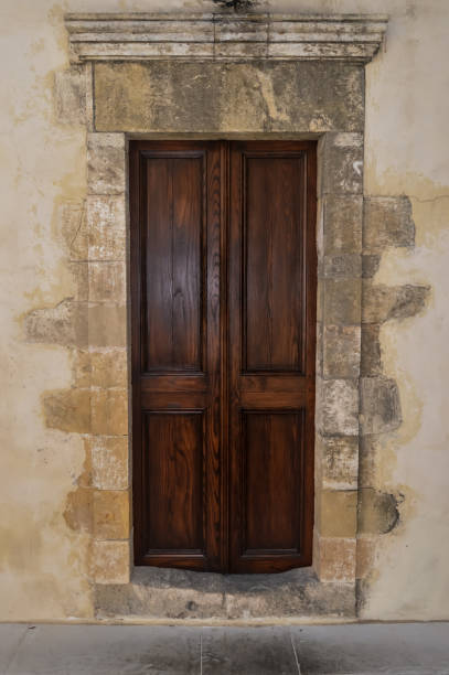 istock A dark wooden door on a stony wall 858663932
