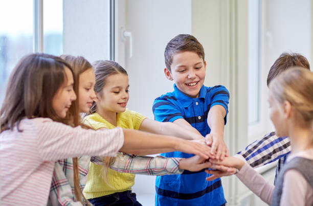 istock group of smiling school kids putting hands on top 858670606